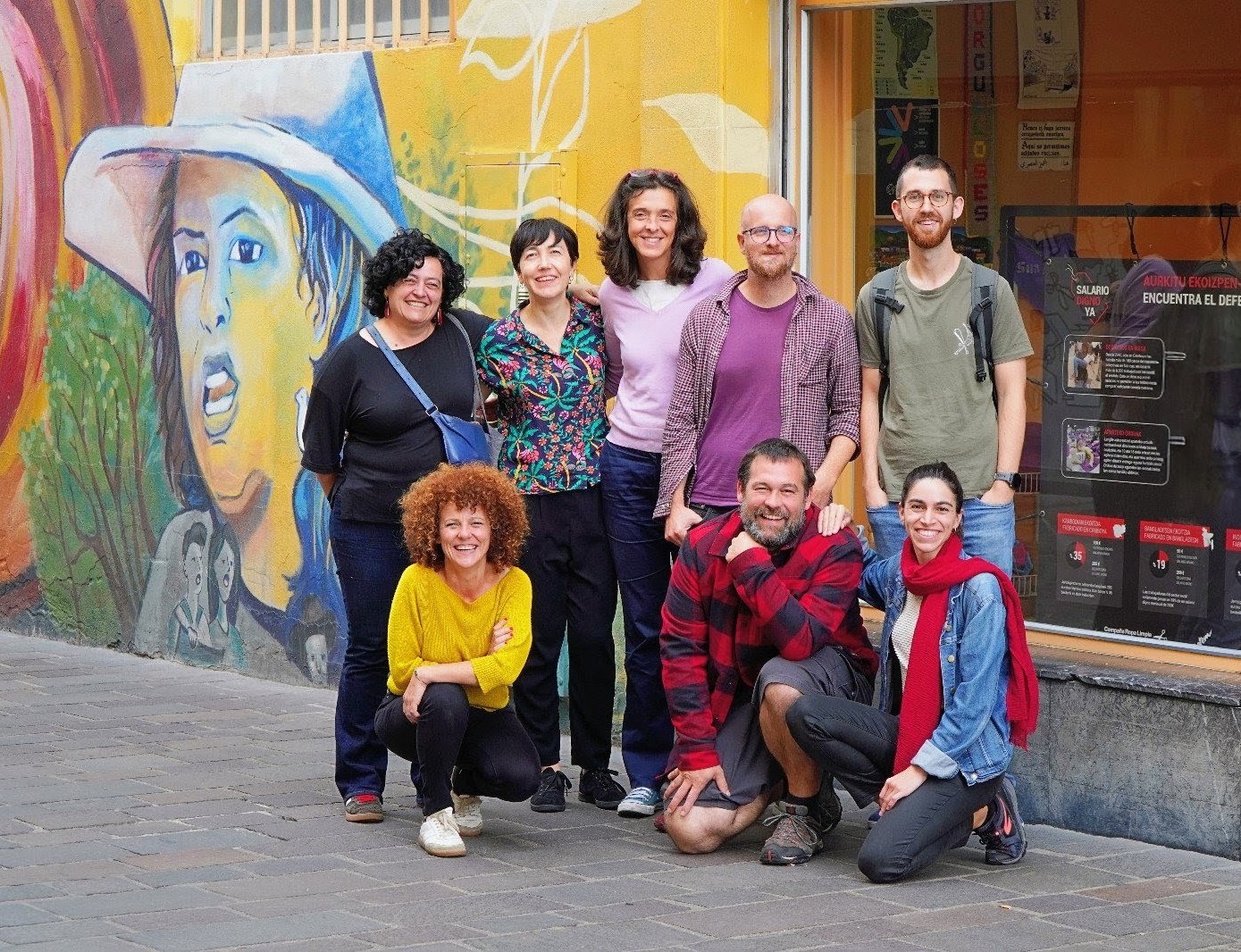 Junta directiva de REAS Euskadi en la calle, delante de un mural de colores