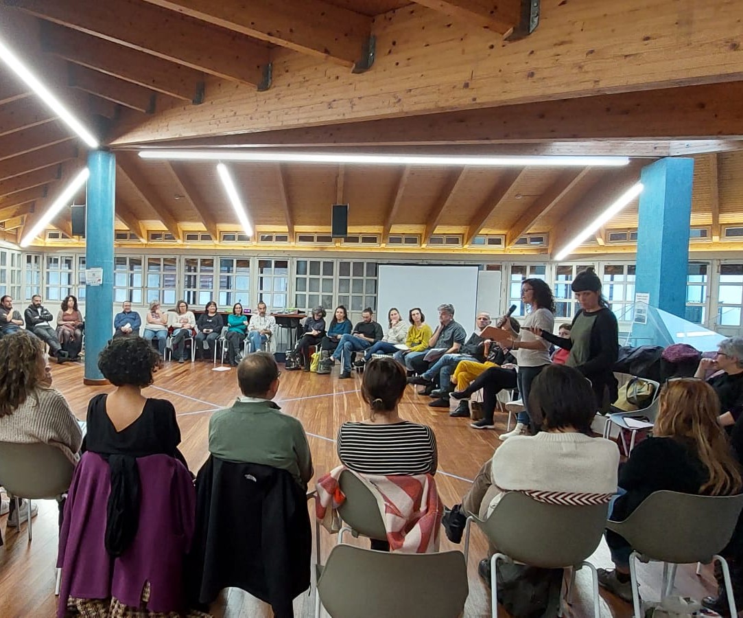 Asamblea de REAS Euskadi con las personas sentadas en círculo en una sala con techo de madera